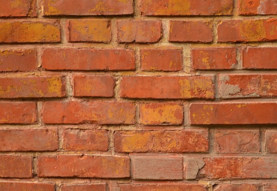 Breathable sealer being applied to a brick wall with a low-pressure sprayer